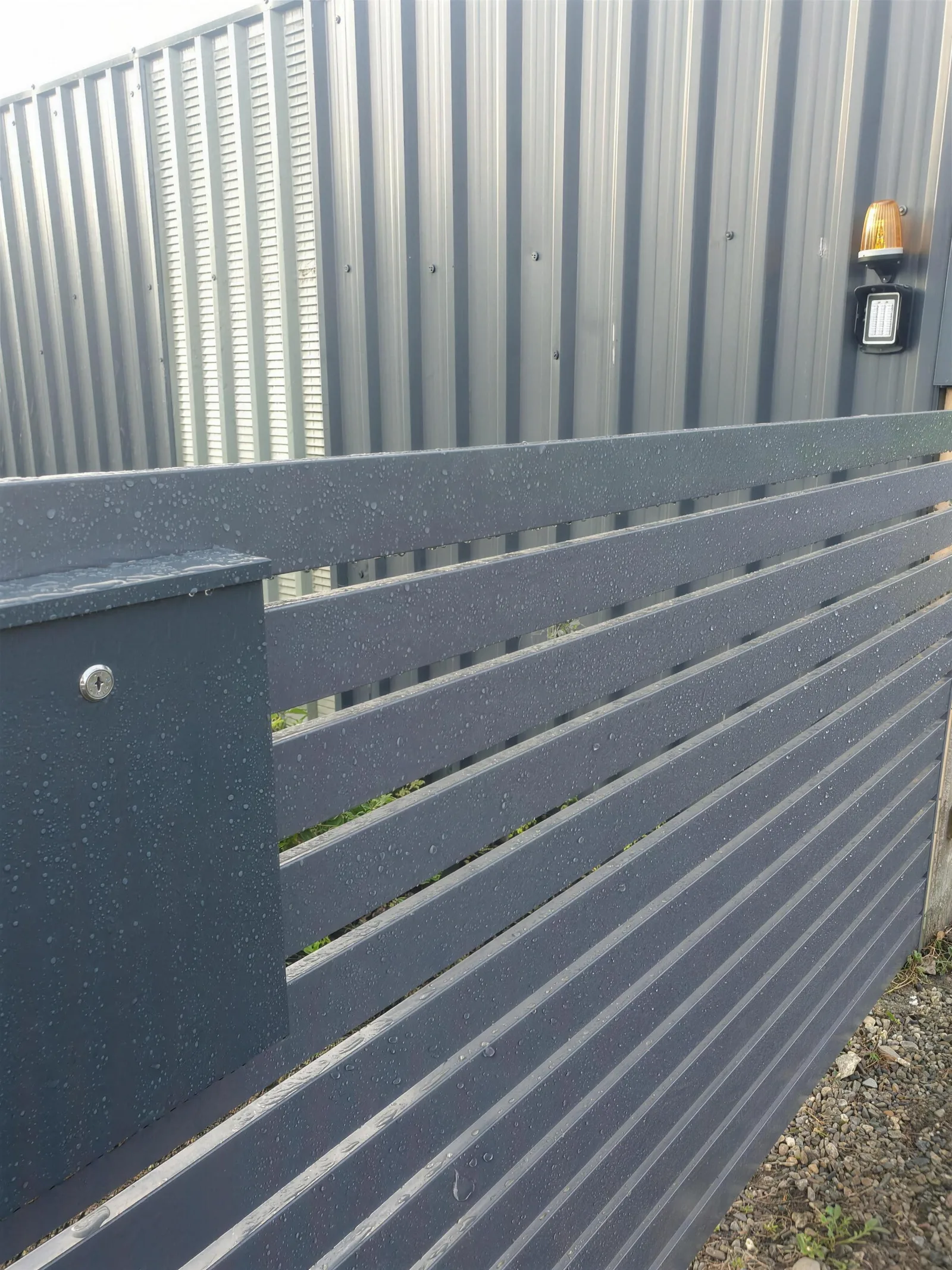 Anthracite slat entrance with post box and keypad gate automation