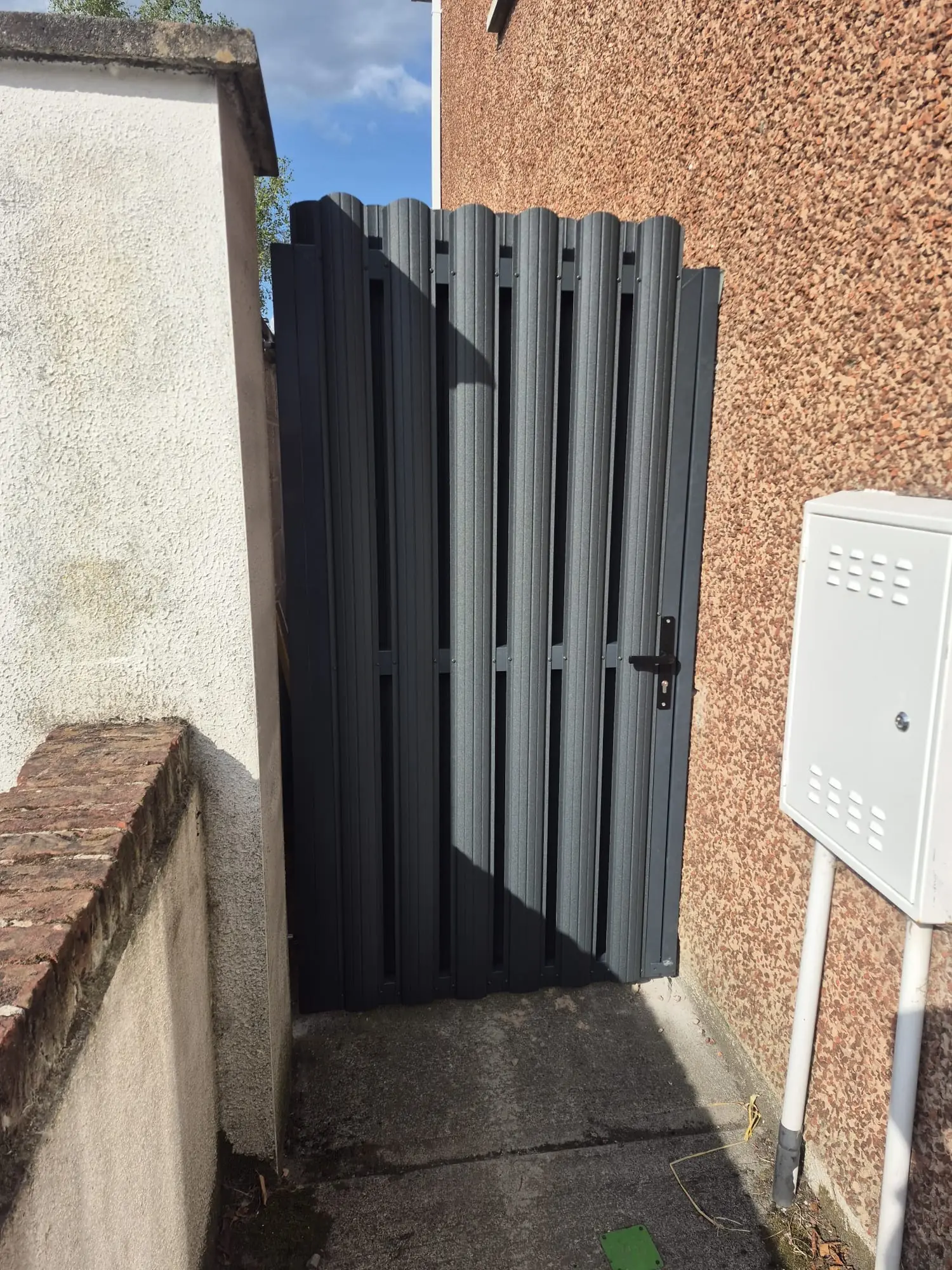 Anthracite vertical picket side gate fitted between pebbledash walls