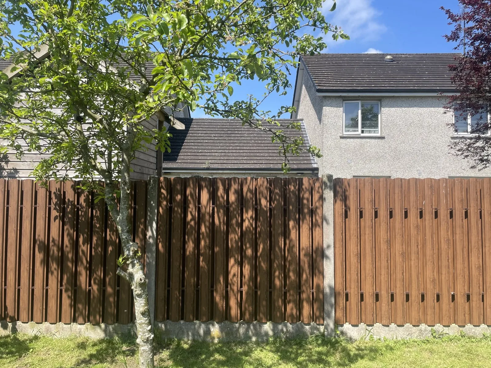 Wood tone vertical board fence around a family home