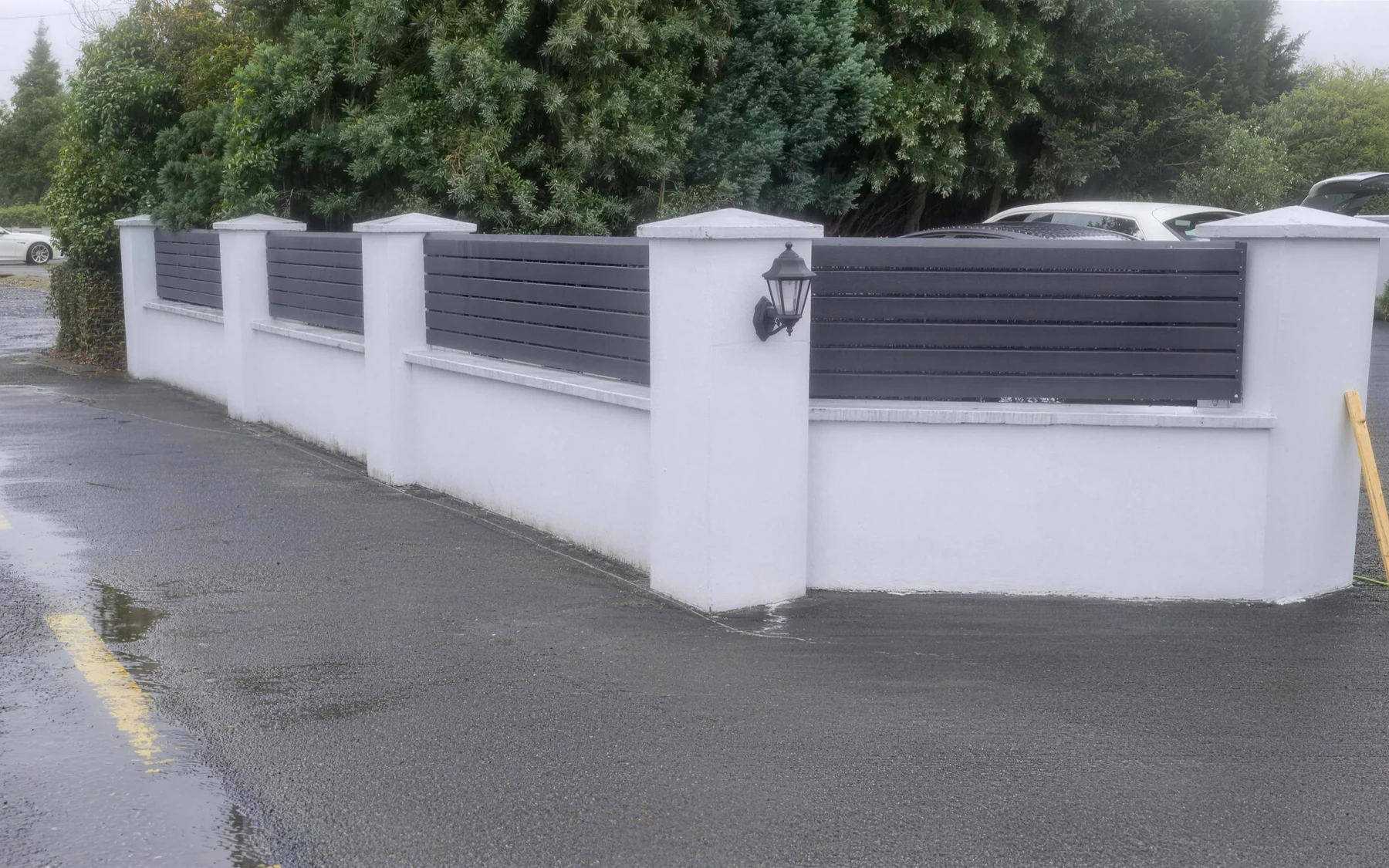 Rendered pillar wall with grey slat panels and lantern