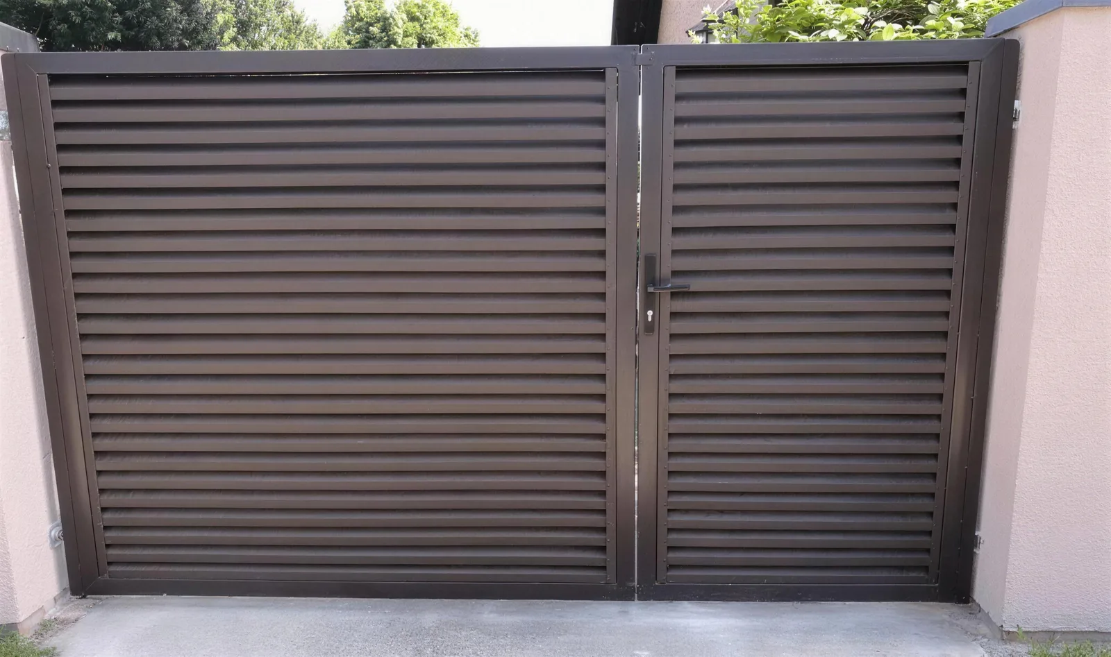 Brown jalousie double gates between rendered pillars